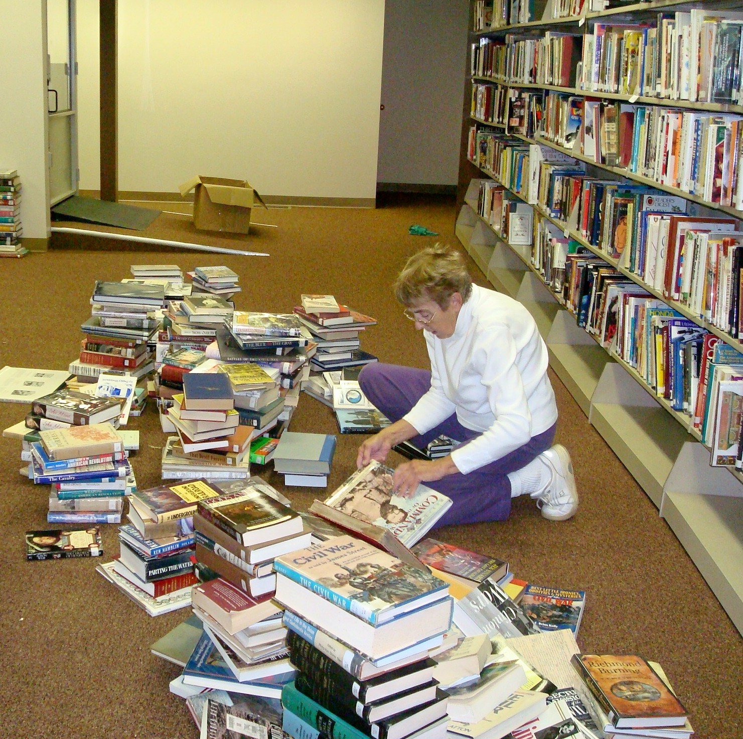 Mrs. Doris Turner sorting thru  library books preparing for reopening of library